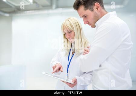Doctor notes médicales sur tablette numérique avec le consultant. Banque D'Images