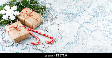 Cadeaux de Noël, avec les cônes de branches de sapin, des cannes de bonbon sur un fond clair Banque D'Images