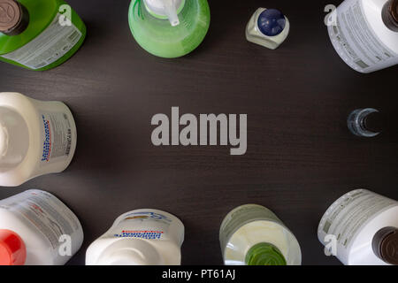 Un fond en bois noir avec divers produits de beauté corps et cheveux : shampooing, gel douche, crème hydratante, lotion pour les mains. Banque D'Images