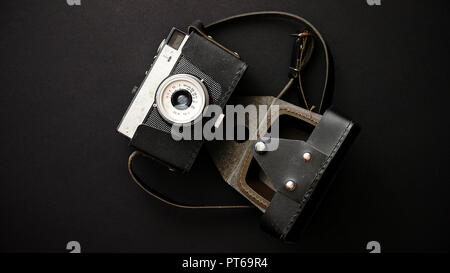 Vieux film retro caméra en cas de cuir sur fond noir Banque D'Images