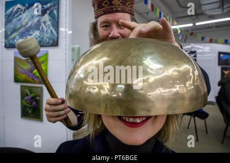 En utilisant le bol chantant tibétain au cours d'une séance de thérapie sonore au Népal Culture Festival à Moscou, Russie Banque D'Images