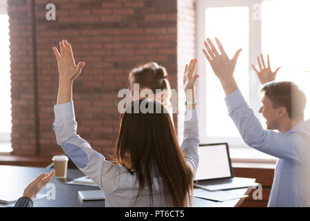 Vue arrière sur les employés heureux excité par les mains des succès Banque D'Images