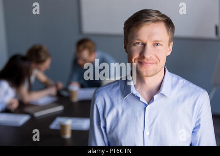 Portrait of smiling chef d'entreprise réussie avec l'équipe à backgrou Banque D'Images