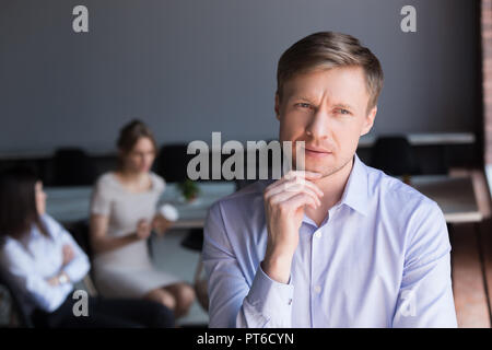 Douteuse réfléchie middle aged businessman looking away Rosa Banque D'Images