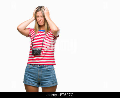 Belle jeune femme prendre des photos à l'aide de l'appareil photo vintage sur fond isolés souffrant de maux désespérés et souligné parce que la douleur Banque D'Images