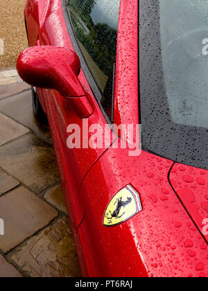 Le rétroviseur et le logo Ferrari sous la pluie montrant une carrosserie d'au-dessus Banque D'Images