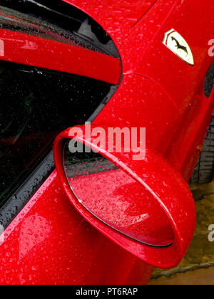 Le rétroviseur et le logo Ferrari sous la pluie montrant une carrosserie d'au-dessus Banque D'Images