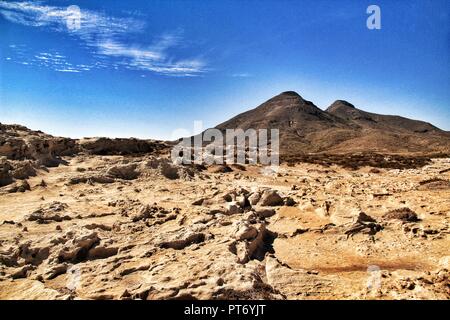 La texture des dunes fossilisées à Cabo de Gata, Almeria, Espagne. Les volcans dans l'arrière-plan sous ciel bleu. Banque D'Images