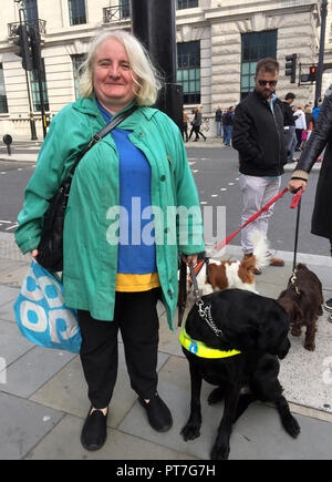 Londres, Royaume-Uni. 07Th Oct, 2018. 07 octobre 2018, l'Angleterre, Londres : Kim Milward, 48, de Northampton, prend part à la manifestation avec son chien-guide Woody. Des centaines de propriétaires de chiens ont démontré avec leurs amis à quatre pattes contre Brexit. Sous la devise 'Wooferendum» ils ont appelé à un référendum sur l'accord final sur le retrait de l'UE. Credit : Christoph Meyer/dpa/Alamy Live News Banque D'Images