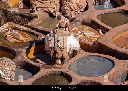 Marrakech MAROC TANNERIE TANNER UNIQUE TRAVAILLANT DANS DES CUVES DE CARRELAGE DES COLORANTS ET MASQUE Banque D'Images