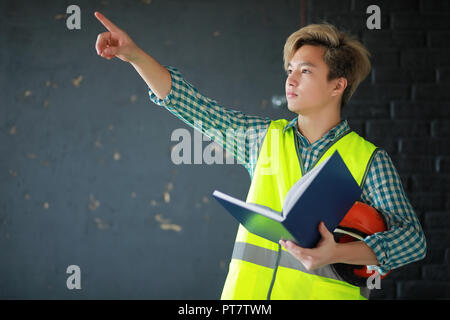 Asian man in casque de protection et la construction gilet. Banque D'Images