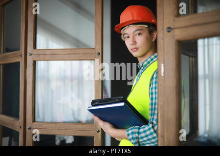 Asian man in casque de protection et la construction gilet. Banque D'Images