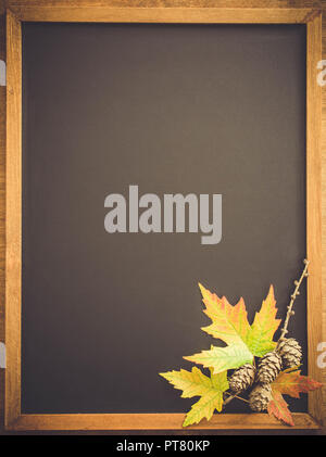 Automne fond avec leavesand l'automne et les cônes sur table en bois. Tableau noir au centre avec l'exemplaire de l'espace pour votre texte. La vie toujours confortable de l'automne. Bac Banque D'Images