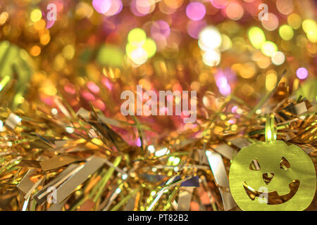 Plein de texture de fond flou d'or de guirlandes décorées par funny jack-o'-lantern pumpkin smiling faces décorations pour Halloween. Banque D'Images