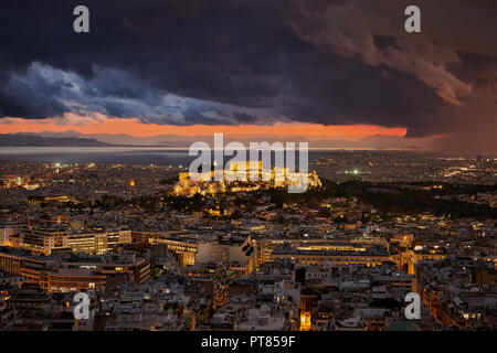 Allumé Acropole d'Athènes la Grèce à ciel nuageux coucher du soleil et de la pluie dans la partie droite de l'image avec la mer et les montagnes à l'arrière-plan Banque D'Images