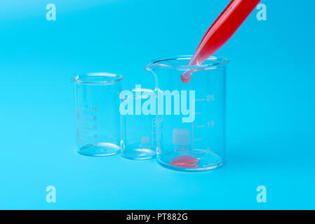 L'équipement médical. Test de sang.Pipetter ajout de liquide à l'une des éprouvettes. Sur un fond bleu. Banque D'Images