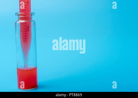 L'équipement médical. Test de sang.Pipetter ajout de liquide à l'une des éprouvettes. Sur un fond bleu. Banque D'Images