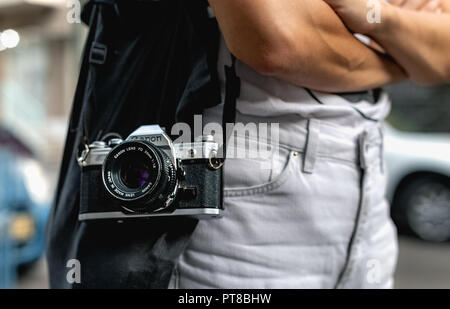 Jeune photographe old school avec un vieux canon AE-1 35mm film SLR camera et Canon FD objectif 50 mm à street à Tel Aviv, Israël Banque D'Images