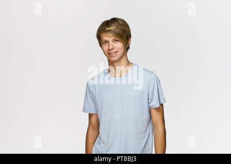 Beau happy smiling young man wearing blue t-shirt studio portrait contre le mur blanc Banque D'Images