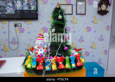 Petit sapin , snowman . bonbons . Petit bonhomme Vintage du prince et un arbre de Noël Bonhomme . dans un chapeau et un foulard coloré sur un fond d'arbres de Noël Banque D'Images
