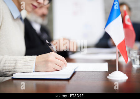 Main de businesswoman ou prendre des notes avec stylo délégué à la conférence de travail Banque D'Images