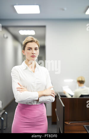 Jeune femme sérieuse en soirée dans la salle de conférence moderne permanent Banque D'Images
