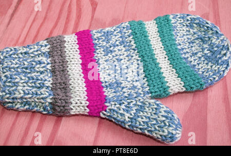 Lumineux et coloré en bleu tricoté main mitten, blanc, rayures rose et vert Banque D'Images