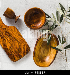 Couverts en bois de l'olivier sur le livre blanc de la table de cuisine et les branches de l'olivier. eco-friendly ustensiles Banque D'Images