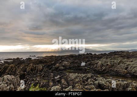 Vue grand angle de rayons crépusculaires sur les montagnes de Mourne et rive rocheuse de St John's Point, comté de Down, Irlande du Nord. Banque D'Images