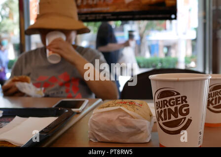 Taipei, Taiwan - le 17 août 2018 : Blur motion de woman eating hamburger et boire un café chaud, dans le fast-food Burger King Banque D'Images