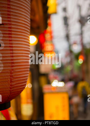 Se concentrer sur une lanterne de papier rouge dans une ruelle sombre de Tokyo au crépuscule. Banque D'Images