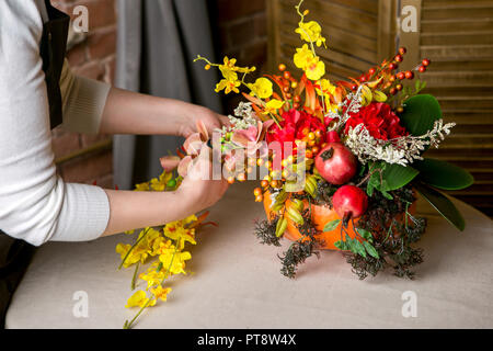 Un fleuriste au travail : Comment faire une pièce maîtresse de l'action de grâce avec grande citrouille et bouquet de fleurs. Pas à pas, tutoriel. Banque D'Images