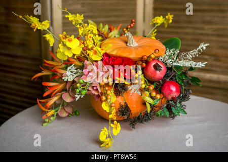Bouquet d'automne lumineux dans une citrouille sur fond sombre Banque D'Images