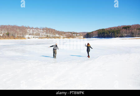 Couple de patiner sur le lac gelé surface Banque D'Images