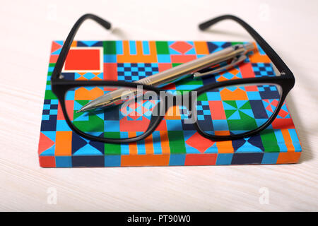 Photo de lunettes et d'un stylo sur le portable. Banque D'Images