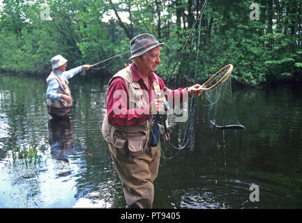 Deux personnes âgées la pêche à la mouche dans une rivière dans le Massachusetts, Etats-Unis Banque D'Images