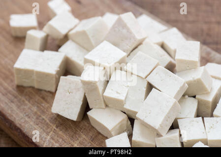 Des cubes de tofu macro planche à découper en bois Banque D'Images