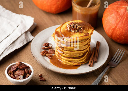 Crêpes à la citrouille faits maison avec de la cannelle, caramel et noix sur table en bois rustique Banque D'Images