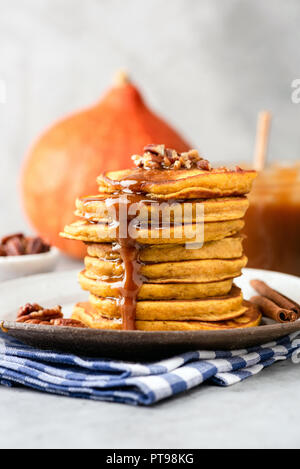 Crêpes à la citrouille avec sauce au caramel et noix sur la plaque, vue rapprochée, composition verticale Banque D'Images