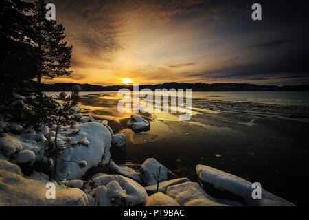 Paysage d'hiver à l'heure du coucher du soleil. Par les rives du lac Jonsvatnet près de Trondheim, en Norvège. Banque D'Images