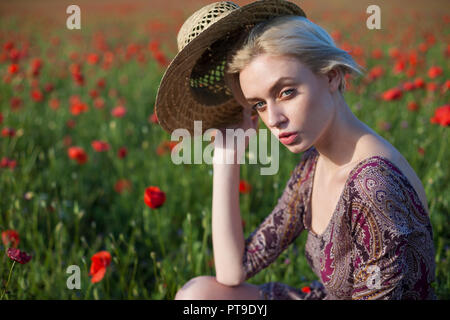 Une agricultrice dans un champ de coquelicots rouges Banque D'Images