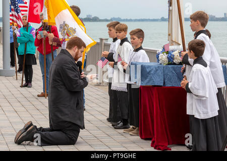 Detroit, Michigan, USA - 7 octobre 2018 - Le Père Stephen Pullis prières mène comme catholiques se rassemblent à la rivière Détroit, la frontière internationale avec le Canada, à prier le Rosaire. Il faisait partie d'un océan à l'autre Rosaire, au cours de laquelle environ 1 000 groupes catholiques se sont réunis à côtes américaines, des frontières, et d'autres lieux publics pour prier le Rosaire. Crédit : Jim West/Alamy Live News Banque D'Images