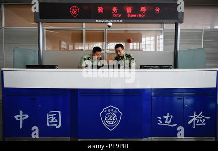 (181008) -- NANJING, 8 octobre 2018 (Xinhua) -- WANG Zhiguo (L) ne l'analyse des données avec des collègues de l'Aéroport International Lukou de Nanjing à Nanjing, capitale de la province de Jiangsu, Chine orientale, 7 août 2018. Wang Jicai, qui utilisé pour être chef de la milice post le Kaishan Island dans la province de Jiangsu, a commencé à travailler sur l'île dans la mer Jaune avec son épouse en 1986. Il est mort de maladie subite en service en juillet de 2018 à l'âge de 58 ans. Wang Zhiguo, fils de Wang Jicai, est devenu un policier de la défense après la fin de ses études à l'Université de Nanjing d'aéronautique et d'astronautique en 2013. Il avait Banque D'Images