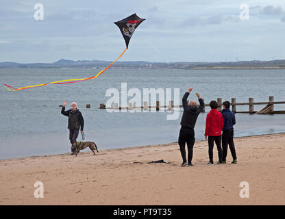 La plage de Portobello, Édimbourg, Écosse, Royaume-Uni. 8 octobre 2018. Family flying kite tête de mort sur une plage tranquille. Banque D'Images