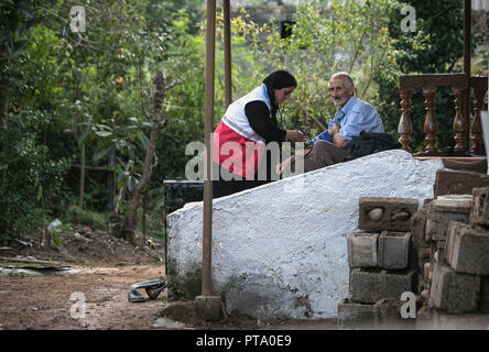 Mazandaran, Iran. 8 octobre, 2018. Un sauveteur propose un villageois un examen médical après les inondations causées par de fortes pluies dans un village de province de Mazandaran, le nord de l'Iran, le 8 octobre 2018. De fortes pluies dans le nord et le nord-ouest de l'Iran le vendredi et samedi a coûté la vie à au moins sept personnes. Credit : Ahmad Halabisaz/Xinhua/Alamy Live News Banque D'Images