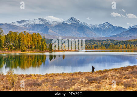 Camp dans les montagnes par le lac. Beau paysage d'automne. Le photographe promenades le long de la côte et fait des photos de sommets enneigés. Banque D'Images