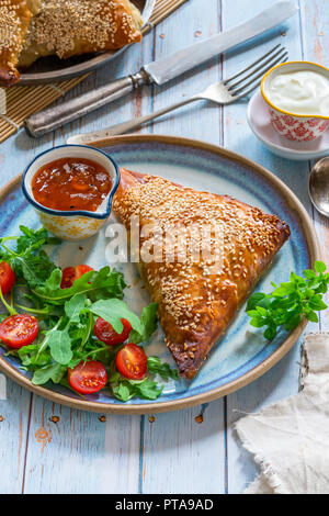 Samossas de poulet géant avec chutney de mangue et une salade fraîche, saupoudré de graines de sésame Banque D'Images