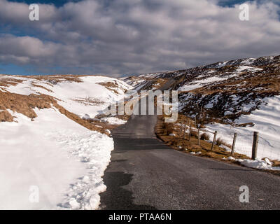 Un chemin de campagne à voie unique à travers vents haute lande couverte de neige sur les collines de la forêt de Bowland dans le Lancashire, dans le nord de l'Angleterre. Banque D'Images