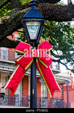 Un lampadaire est dcorated avec un ruban rouge pour Noël à Jackson Square, 11 novembre 2015, à la Nouvelle Orléans, Louisiane. Banque D'Images