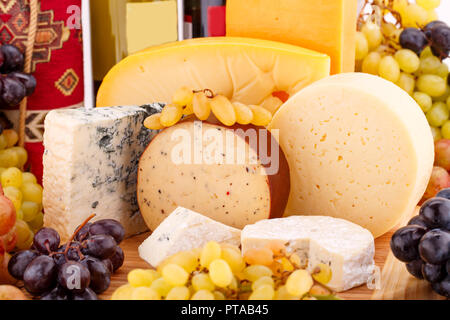 Différents types de fromages, de vins et de raisins photo gros plan sur planche de bois. Banque D'Images